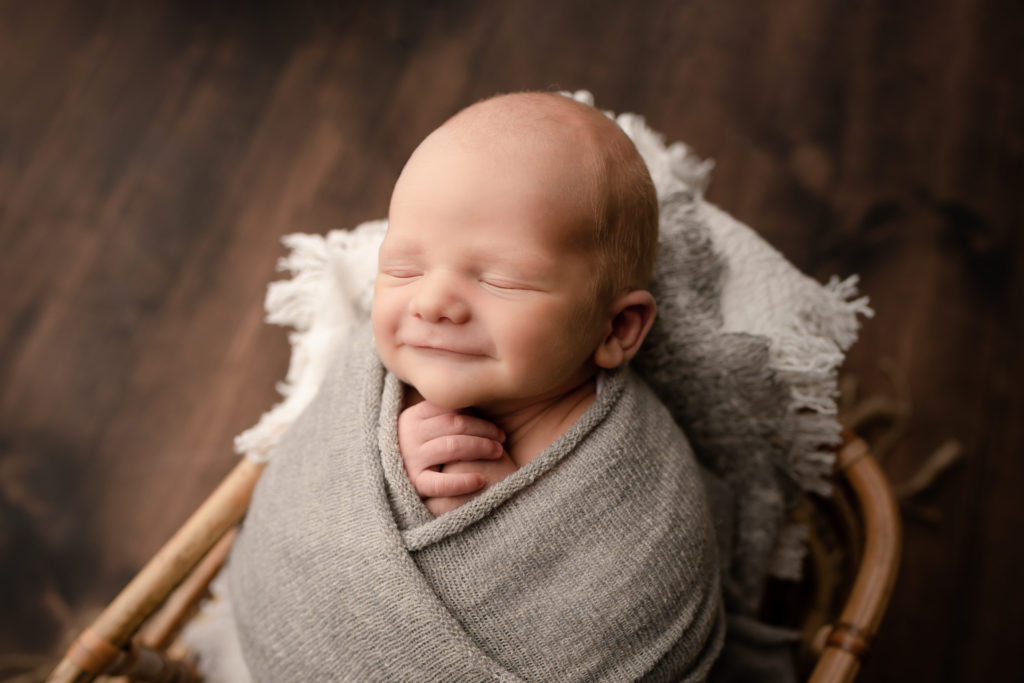 Pace, FL Newborn Photographer Baby Swaddled in Basket Smiling