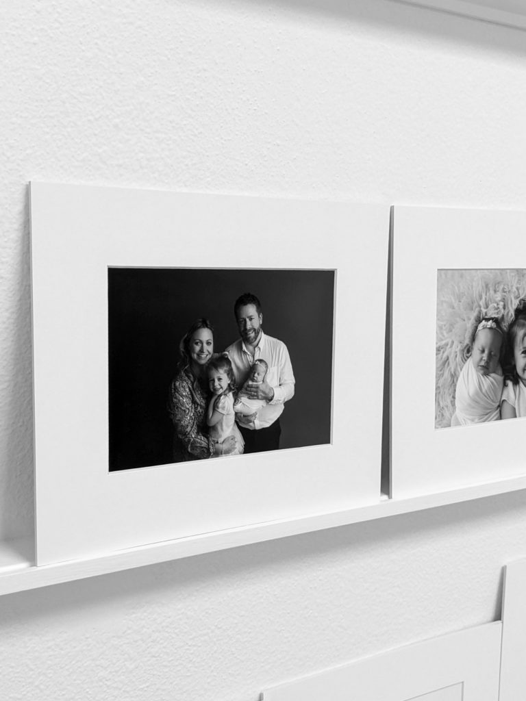Black and white image of framed family image displayed on a shelf