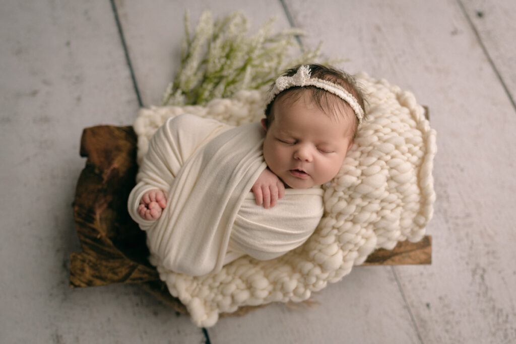 Pensacola,FL Newborn Photographer.  Newborn baby swaddled in white.