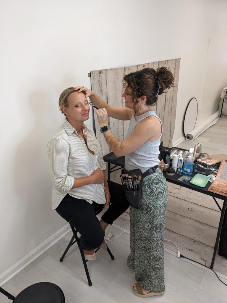 Expecting mother getting makeup applied by an makeup artist