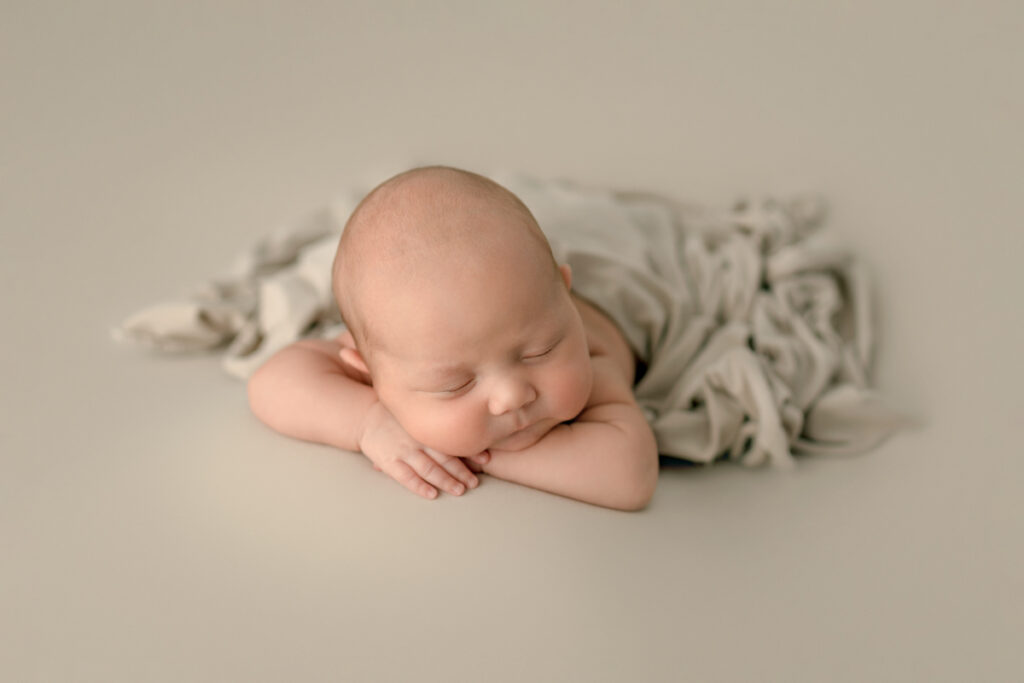 Navarre, FL Newborn Photographer baby posed in chin on hands pose for posed newborn photography session.