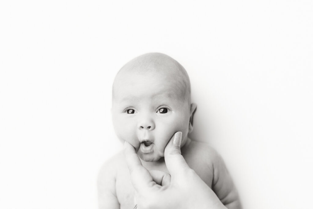 Niceville, FL Newborn Photographer black and white mugshot image of baby during posed newborn studio session.