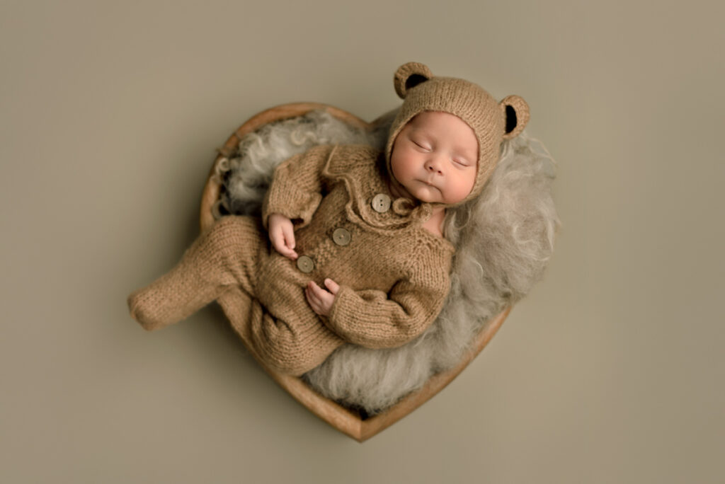 Pace, FL Newborn Photographer Baby dressed in brown teddy bear outfit for posed newborn session.